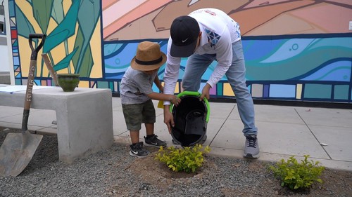 An adult and child doing landscaping work at a new school in Peru